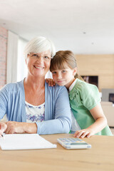 Fototapeta premium Older woman and granddaughter using calculator