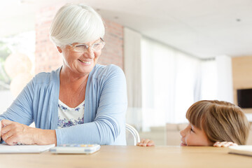 Fototapeta premium Older woman and granddaughter using calculator