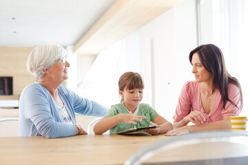 Obraz premium Three generations of women using tablet computer