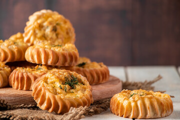 Fresh muffins with vegetables and cheese on wooden board. Delicious homemade cakes for healthy diet. Recipe for autumn seasonal dish.