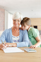 Older woman and granddaughter using calculator