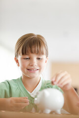 Girl filling piggy bank on counter