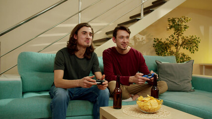 Two men are playing video games and talking 