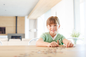Naklejka premium Girl stacking pennies on counter
