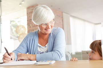 Older woman and granddaughter using calculator