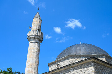 The old mosque, minaret and clock tower. Stone mosque built in Ottoman period. Mosque is a place...