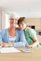 Fototapeta premium Older woman and granddaughter using calculator