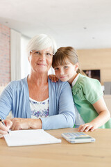 Fototapeta premium Older woman and granddaughter using calculator
