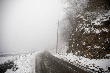 Fototapeta premium Winter trees in mountains covered with fresh snow. Beautiful landscape with branches of trees covered in snow. Mountain road in Caucasus. Azerbaijan