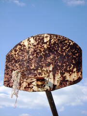 rusted basketball hoop against the sky