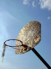 rusted basketball hoop against sky