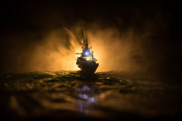 Silhouettes of a crowd standing at blurred military war ship on foggy background. Selective focus.