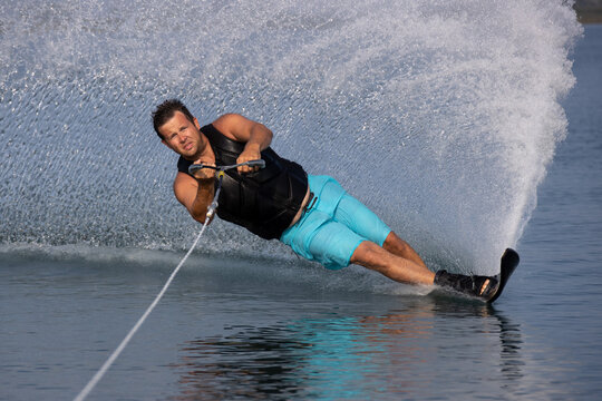 Man waterskiing and making spray.