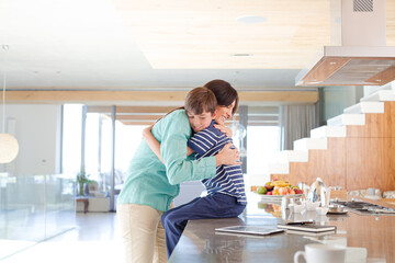 Mother and son smiling in kitchen