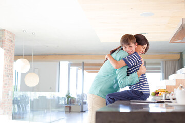 Mother and son hugging in kitchen