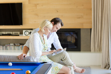 Obraz premium Couple using tablet computer on sofa