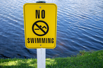 No Swimming sign by water and grass