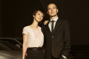 Happy young fashion couple in love on city street at night