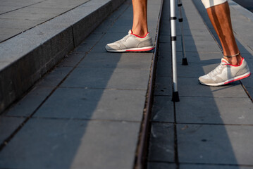 Close up of man with crutches climbing stair steps