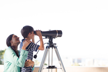 Mother and son using telescope