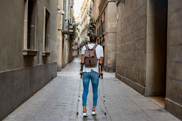 Young latin man with crutches visiting the city