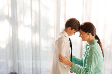 Obraz premium Mother and son touching foreheads at window