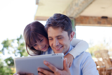 Father and daughter using tablet computer together