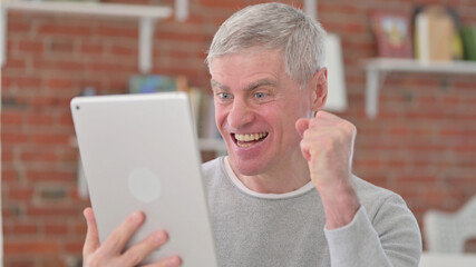 Old Man Celebrating Success on Tablet