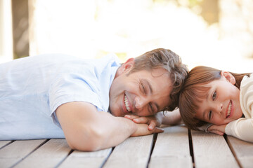 Father and daughter lying on porch