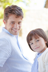 Father and daughter smiling outdoors