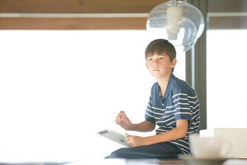 Boy using tablet computer in modern house