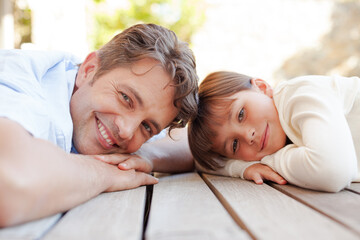 Father and daughter lying on porch