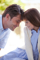 Father and daughter touching foreheads outdoors