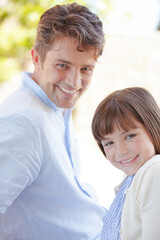 Father and daughter smiling outdoors