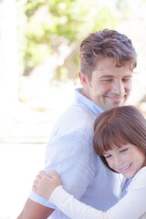 Father and daughter hugging outdoors