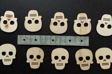 halloween theme with wooden shapes and metal object arranged on a black paper background