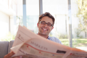 Businessman reading newspaper on sofa