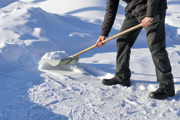 Man shoveling snow, raises and throws, on winter day