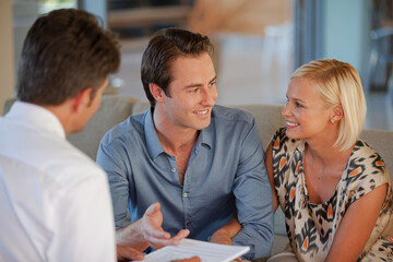 Financial advisor talking to couple on sofa