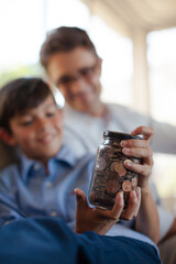 Father and son holding change jar