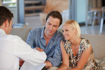 Financial advisor talking to couple on sofa