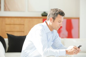 Businessman using cell phone in office