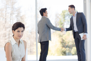 Businessmen shaking hands in office