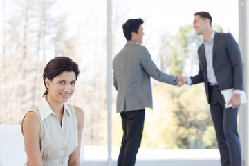 Businessmen shaking hands in office