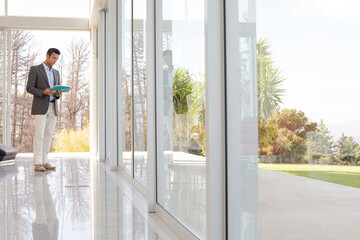 Businessman holding folders at office window