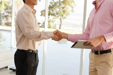 Businessmen shaking hands in office