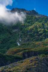 beautiful view of mountain with waterfall and white cloud on foreground