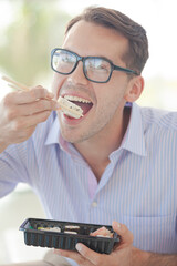 Businessman eating sushi in office