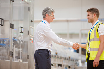 Obraz premium Supervisor and worker shaking hands in factory