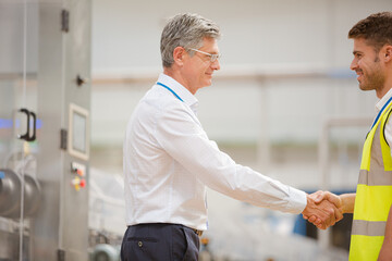 Obraz premium Supervisor and worker shaking hands in factory